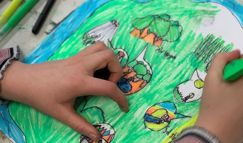 Händerna hos ett barn som ritar en teckning.